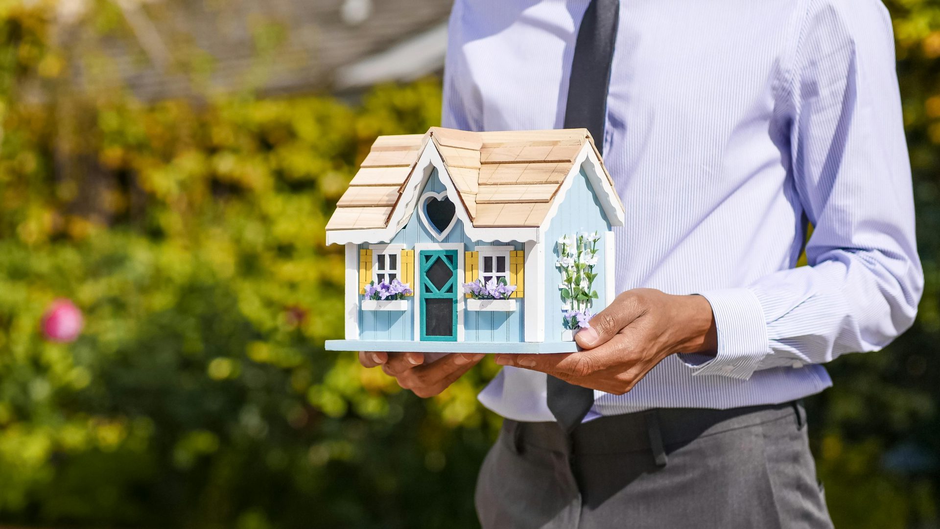 Person Holding Miniature Wooden House